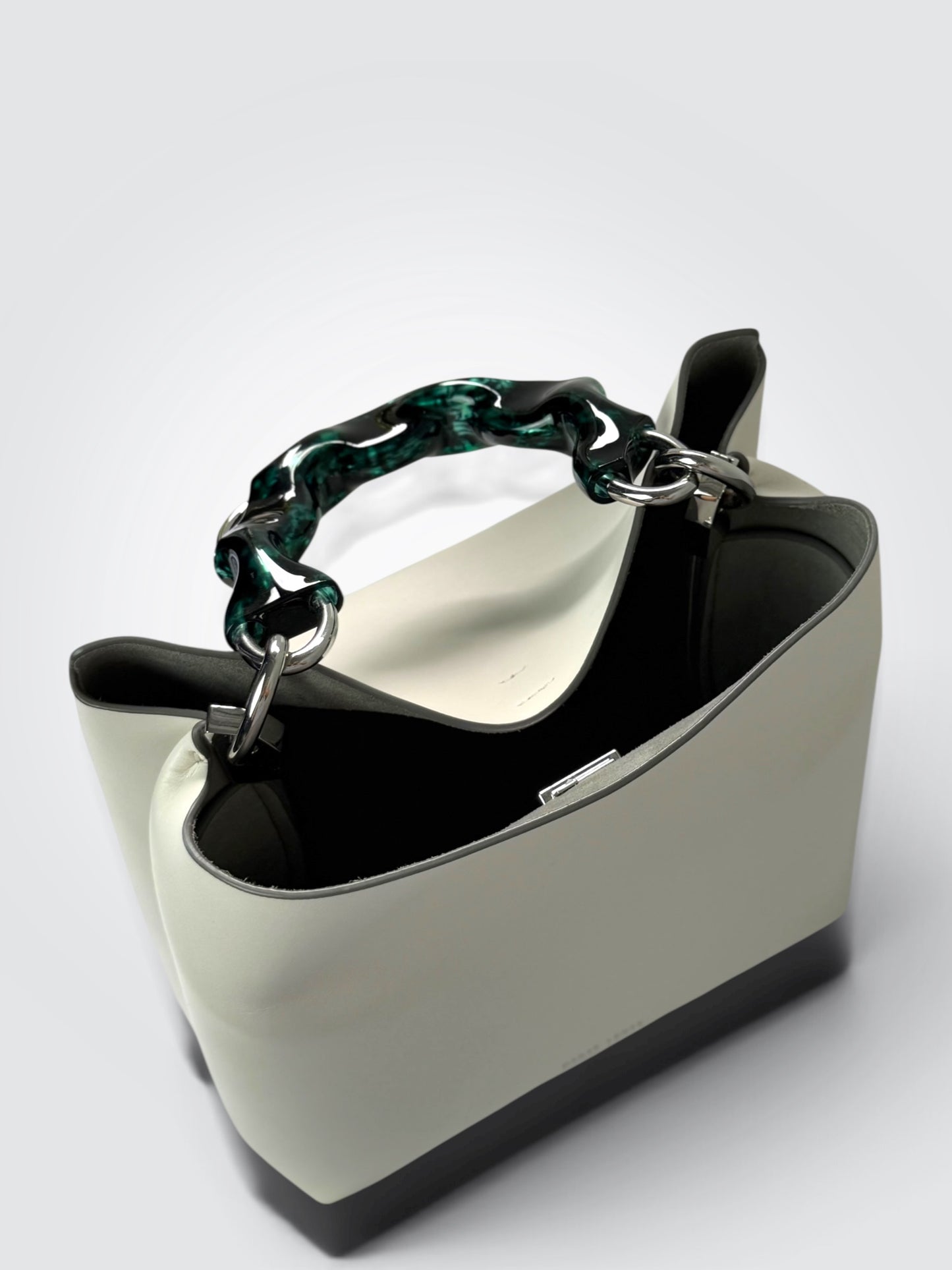white Danse Lente bucket bag featuring a distinct marbled green resin top handle.