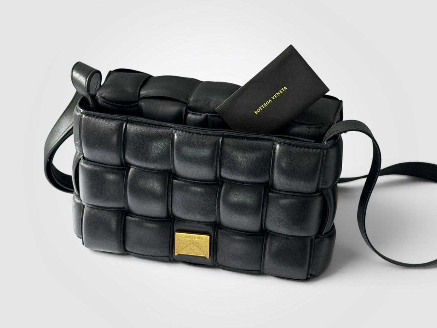 Pre-owned Bottega Veneta Padded Cassette bag in black with signature puffy intrecciato weave and gold-tone hardware