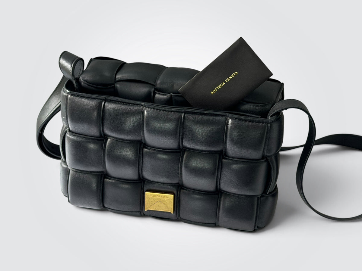 Pre-owned Bottega Veneta Padded Cassette bag in black with signature puffy intrecciato weave and gold-tone hardware