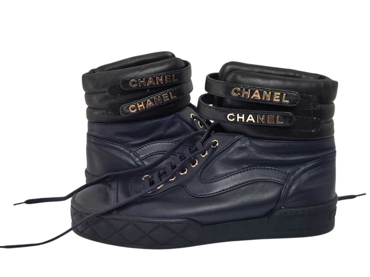 Pre-owned Chanel black leather high-top sneakers with gold CC logo strap detail and lace-up closure, size 41 — available at Style Reissue Vancouver