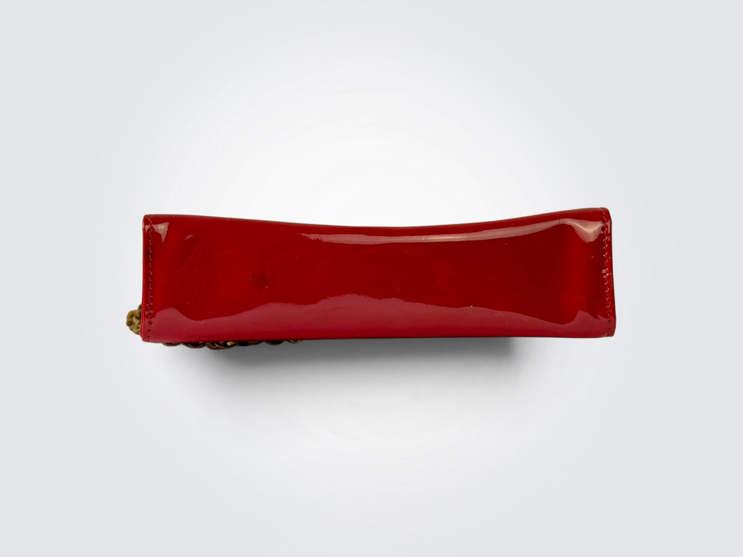 The glossy red patent leather Salvatore Ferragamo Vara Bow bag features a signature grosgrain ribbon bow accent and polished gold-tone chain strap.