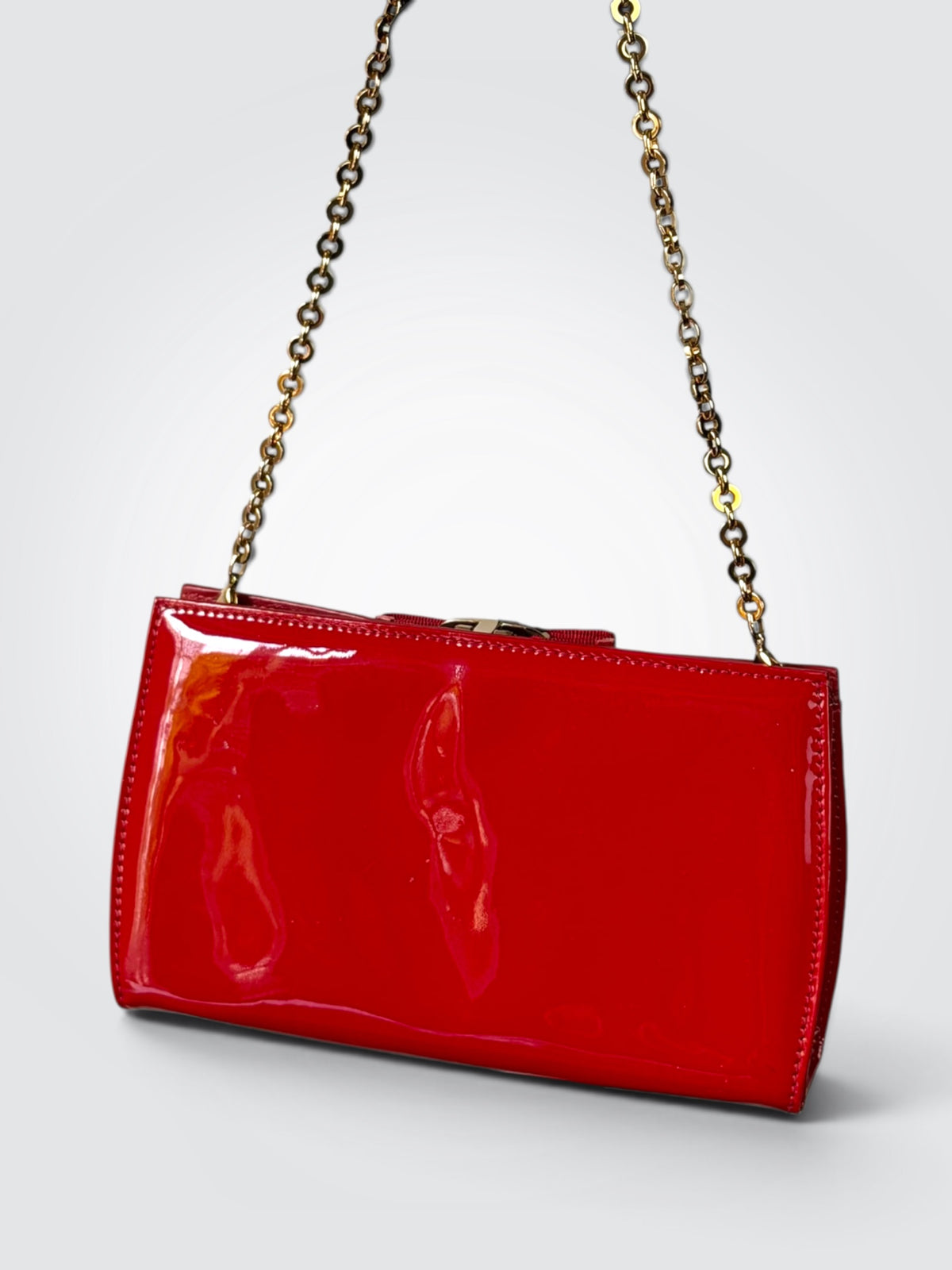 The glossy red patent leather Salvatore Ferragamo Vara Bow bag features a signature grosgrain ribbon bow accent and polished gold-tone chain strap.
