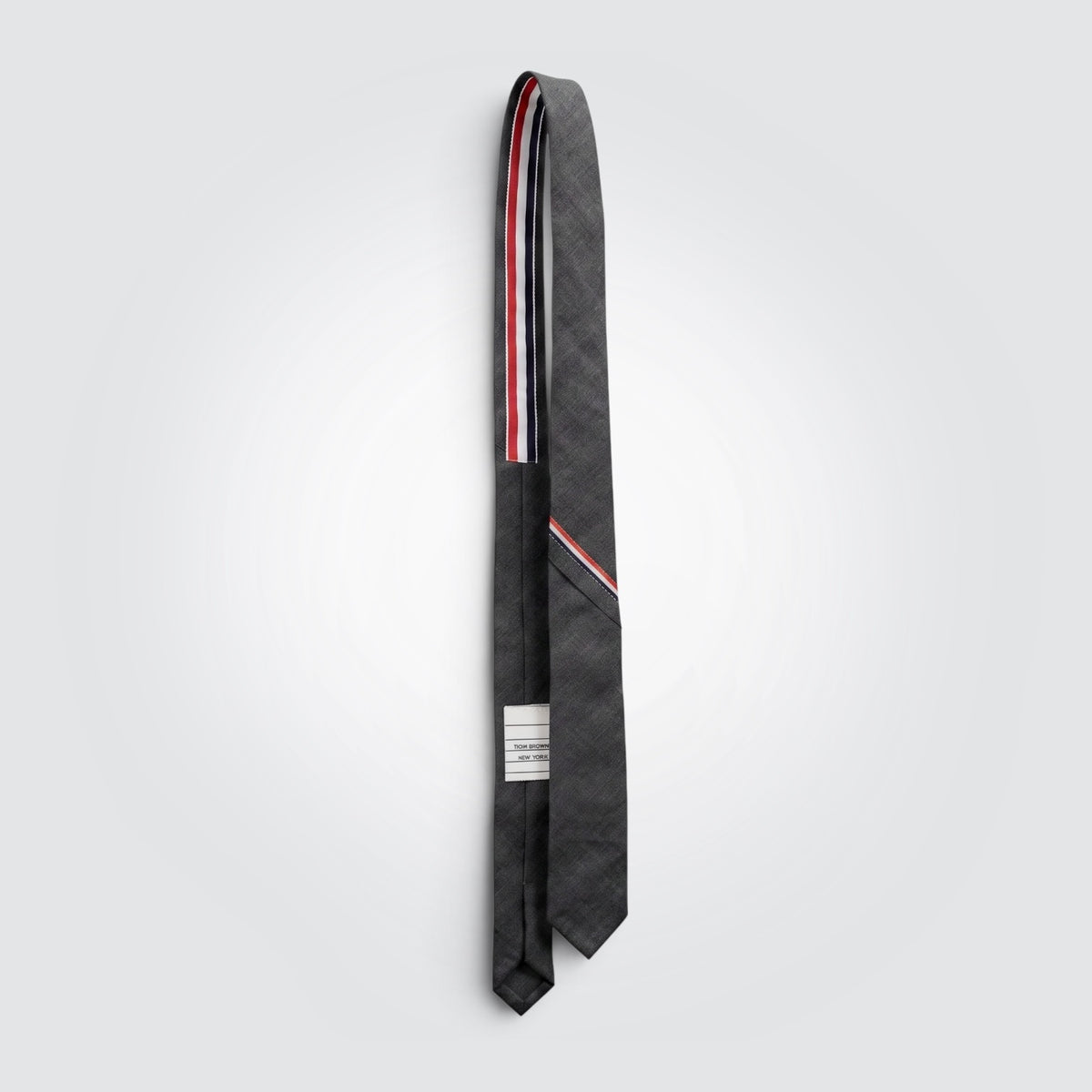 Pre-owned Thom Browne New York dark grey 100% wool tie with signature red, white and blue diagonal stripe detail — available at Style Reissue Vancouver