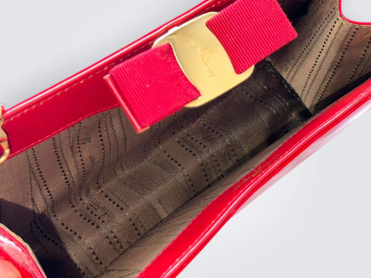 The glossy red patent leather Salvatore Ferragamo Vara Bow bag features a signature grosgrain ribbon bow accent and polished gold-tone chain strap.