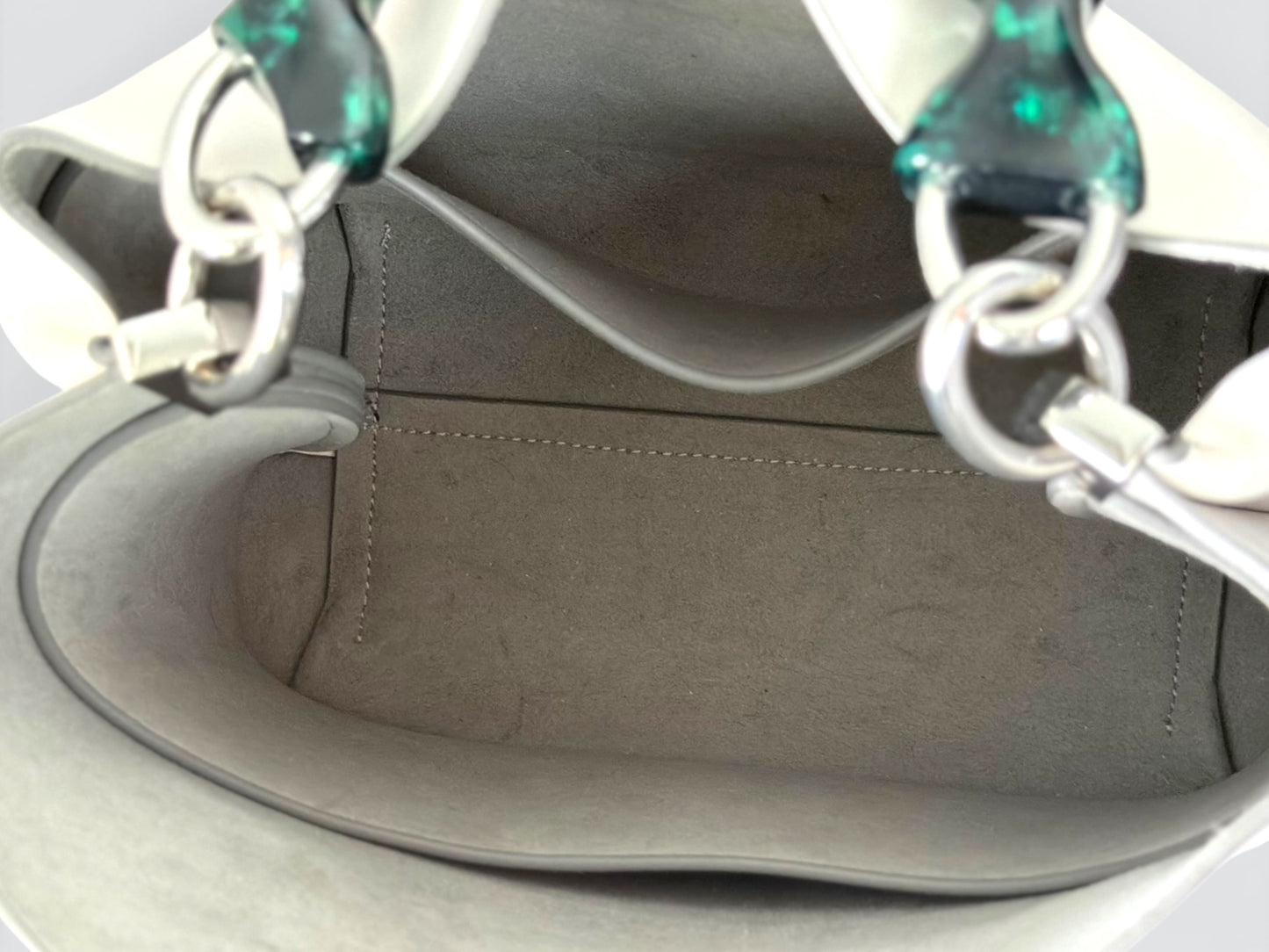white Danse Lente bucket bag featuring a distinct marbled green resin top handle.