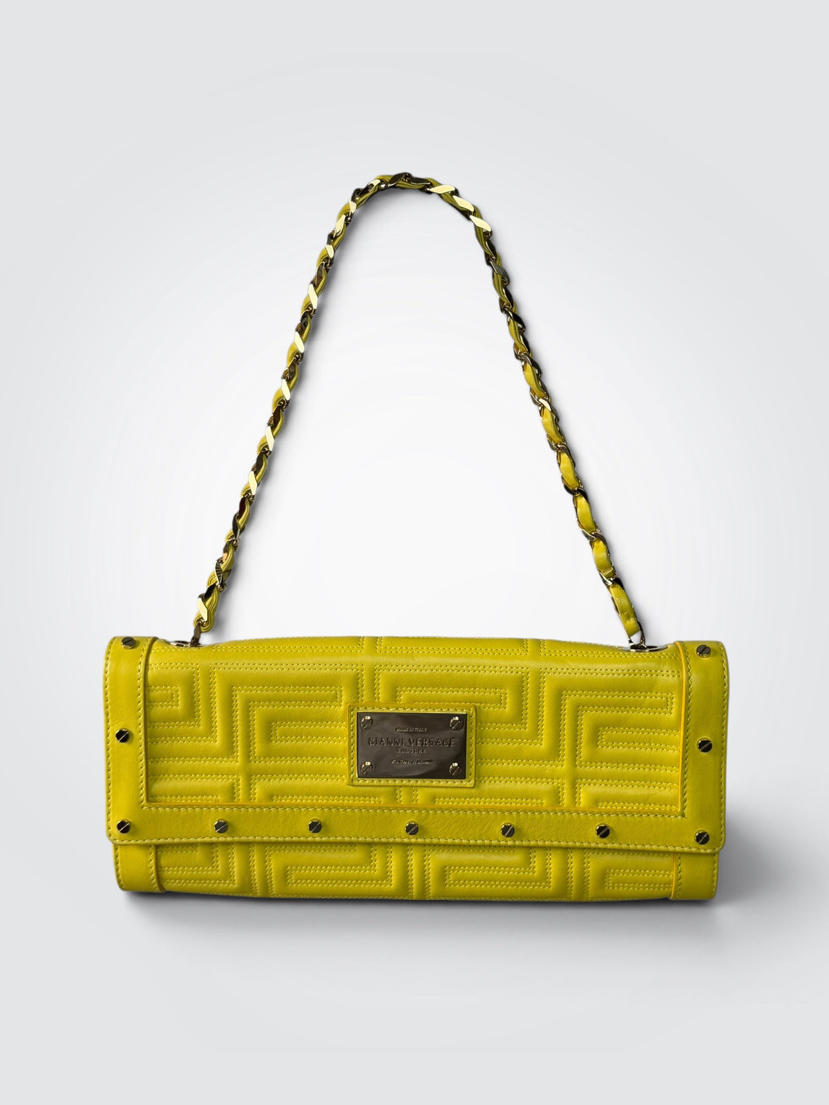 Pre-loved vintage Gianni Versace Couture yellow leather flap handbag with embossed branding, geometric Greek-key motif, branded metal plaque, and gold-tone chain strap