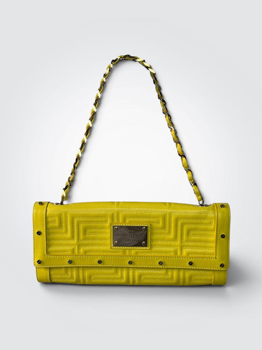 Pre-loved vintage Gianni Versace Couture yellow leather flap handbag with embossed branding, geometric Greek-key motif, branded metal plaque, and gold-tone chain strap