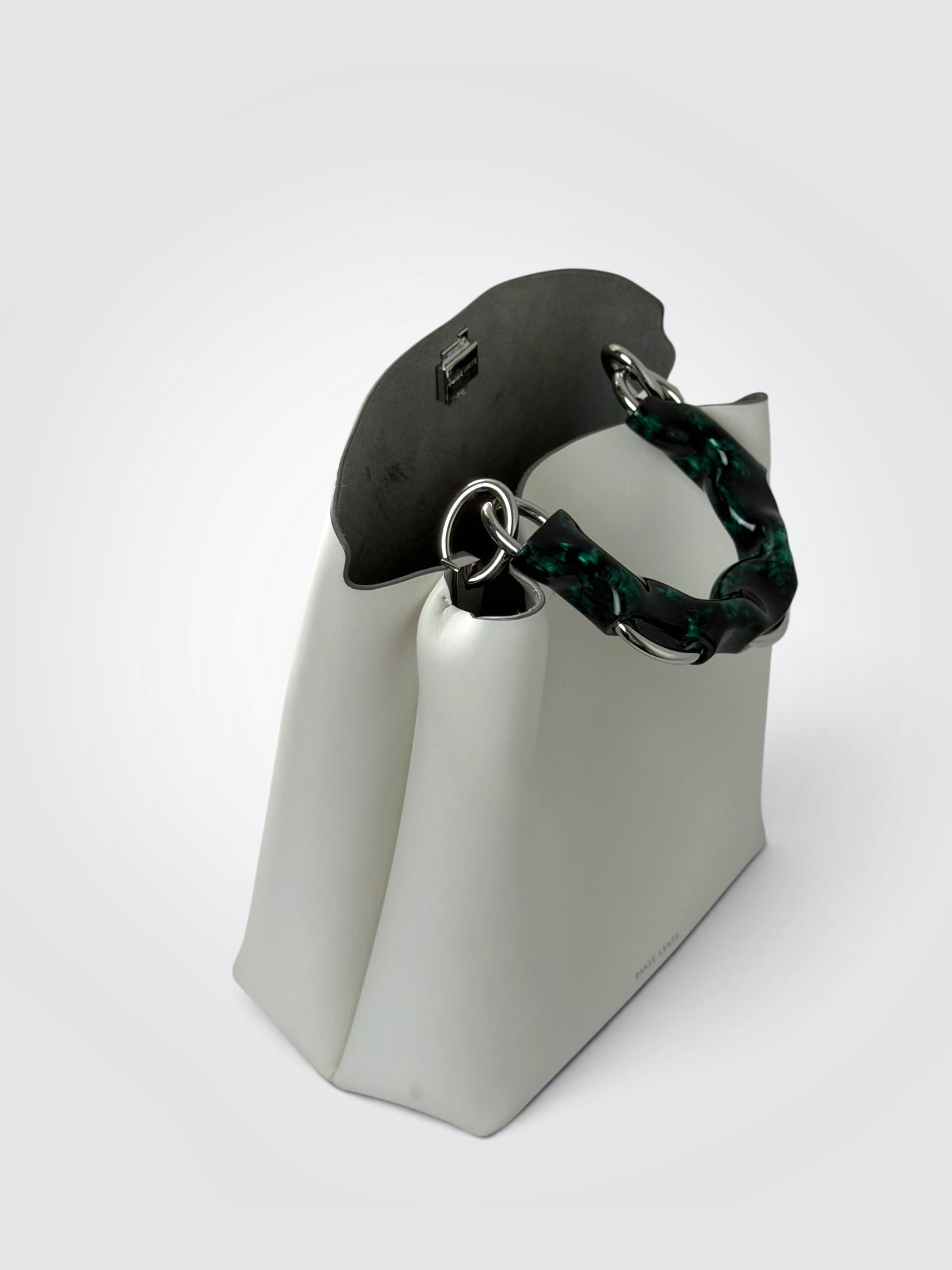 white Danse Lente bucket bag featuring a distinct marbled green resin top handle.