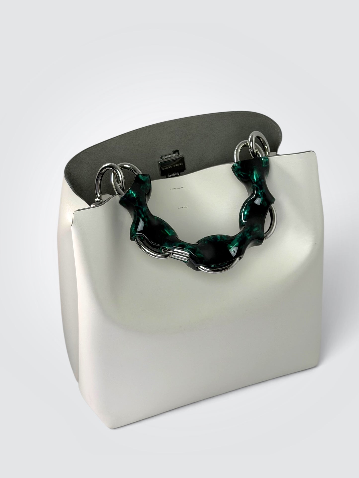 white Danse Lente bucket bag featuring a distinct marbled green resin top handle.