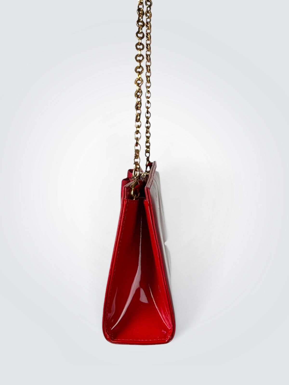 The glossy red patent leather Salvatore Ferragamo Vara Bow bag features a signature grosgrain ribbon bow accent and polished gold-tone chain strap.