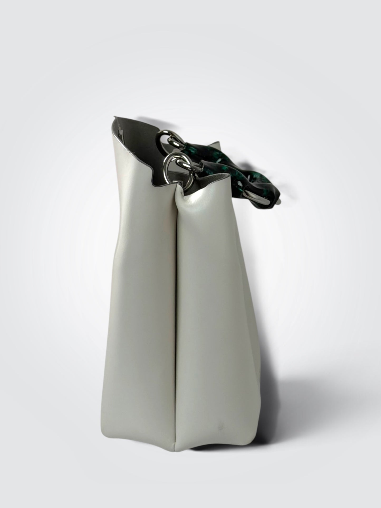 white Danse Lente bucket bag featuring a distinct marbled green resin top handle.