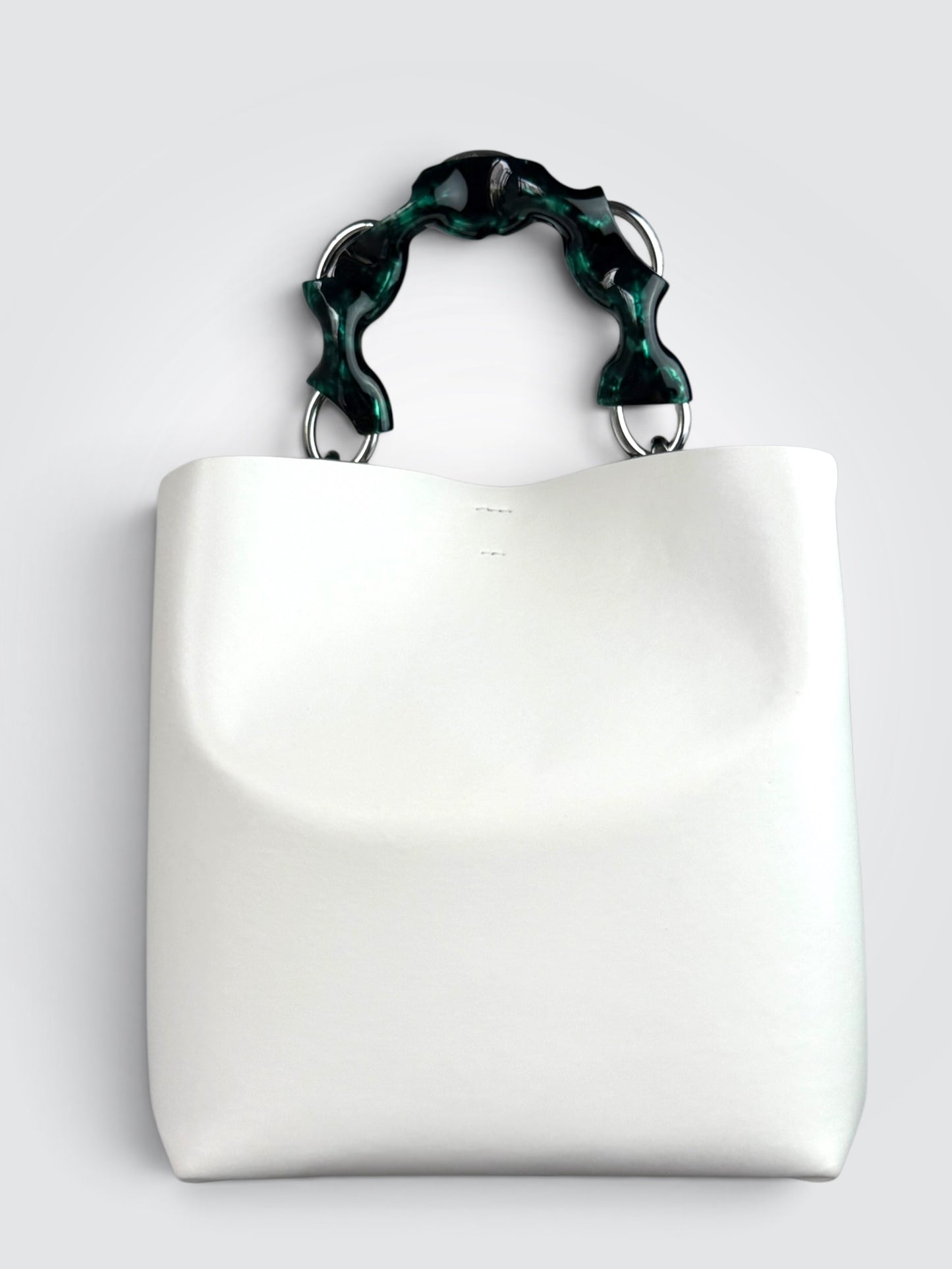 white Danse Lente bucket bag featuring a distinct marbled green resin top handle.