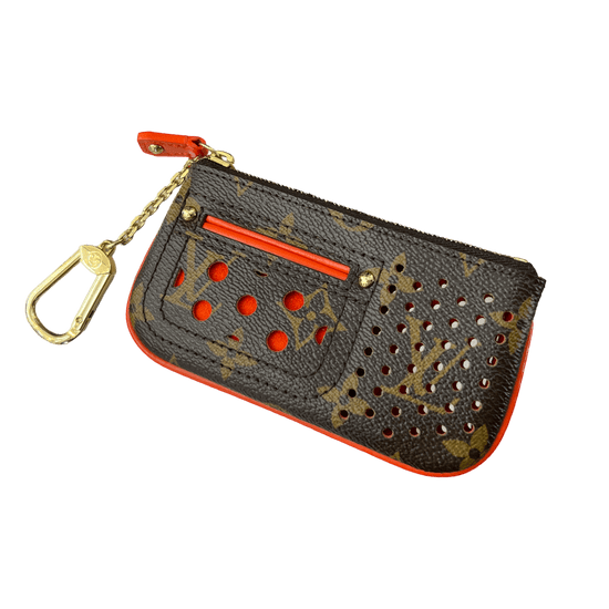 Close-up of a Louis Vuitton Perforated Key Pouch, featuring the iconic LV monogram pattern and perforated design. The pouch is made of Monogram Canvas and has a compact size suitable for holding keys or small essentials