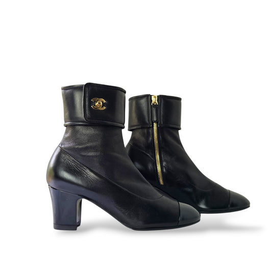 Pre-owned Chanel black leather ankle boots in EU 36 with fold-over cuff, gold CC logo, patent leather cap toe, and side zipper
